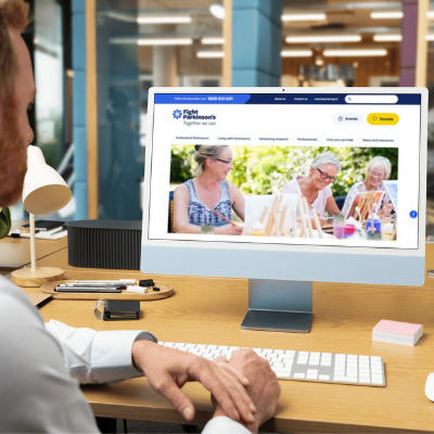 Stock photo mockup of the new Fight Parkinsinson's website on an office computer