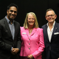 Dr Kishore Kumar, Sheenagh Bottrell, and Victor McConvey standing together indoors at the Fight Parkinson’s 2025 Research Symposium. They are wearing formal attire, including a bright pink blazer and dark suits, with name badges visible, representing speakers and contributors to discussions on Early and Young Onset Parkinson’s research and lived experiences.