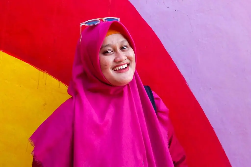 Parkinson's research hope: Woman in hijab smiling at the camera in colorful garb and background