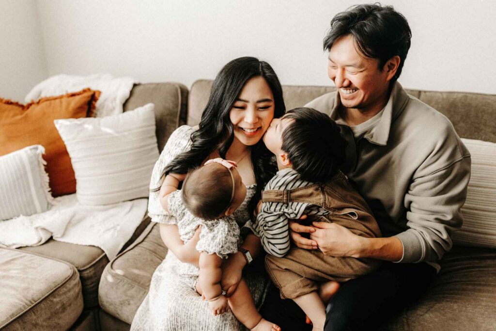A young couple spending time with their two children in their home